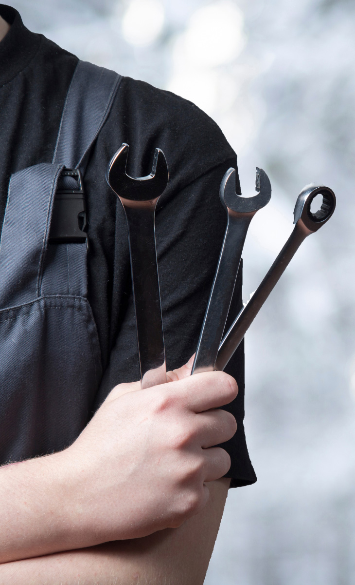 Auto technician holding tools, ready to assist with vehicle repairs and services at Scotty's Auto in Fort Myers, FL. Contact Us